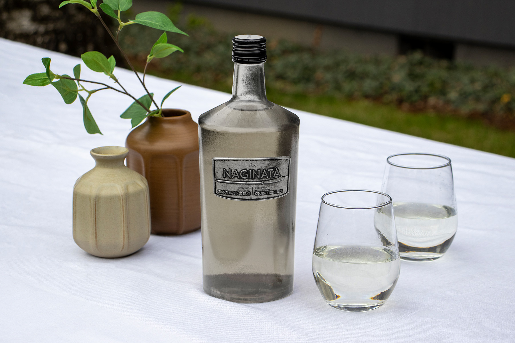 Bottle of Naginata Sake on a Table with Two Full Glasses